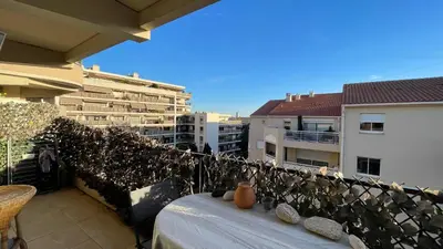 a table with a vase sitting on top of a balcony at Comfortable and modern two bedroom in Cannes