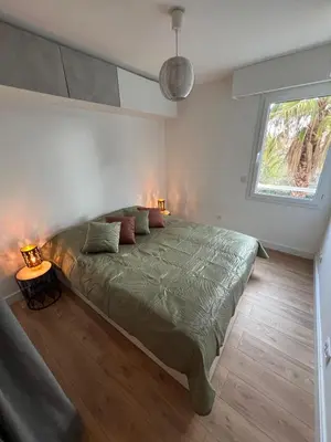 a bedroom with a large green bed with two lamps at Appartement T3 Cannes centre in Cannes