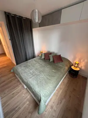 a bedroom with a large green bed with two lamps at Appartement T3 Cannes centre in Cannes