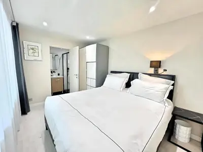 a bedroom with a large white bed with white pillows at Villa Marsa - Cannes - on beach in Cannes