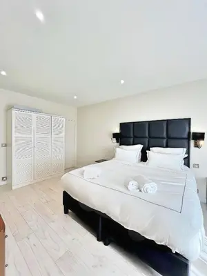 a bedroom with a large bed with two towels on it at Villa Marsa - Cannes - on beach in Cannes