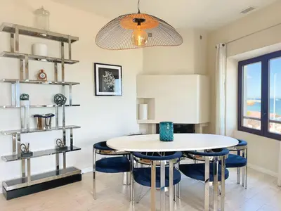 a dining room with a white table and blue chairs at Villa Marsa - Cannes - on beach in Cannes