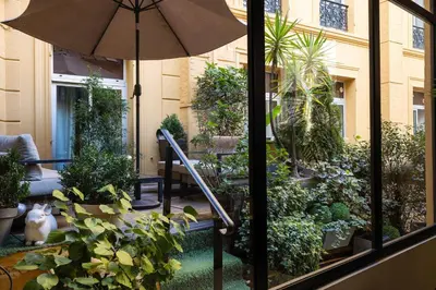a patio with an umbrella and some plants at Crisol Lumière in Cannes