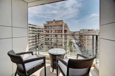 a balcony with chairs and a table and a view of a building at Carlton Riviera Cannes - Dernier étage - Palme d'Or in Cannes