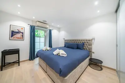a bedroom with a blue bed and a window at Cannes centre maison bourgeoise in Cannes