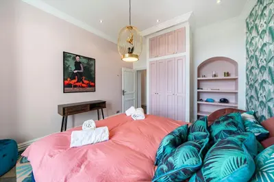 a bedroom with a large pink bed and a couch at Cannes centre maison bourgeoise in Cannes