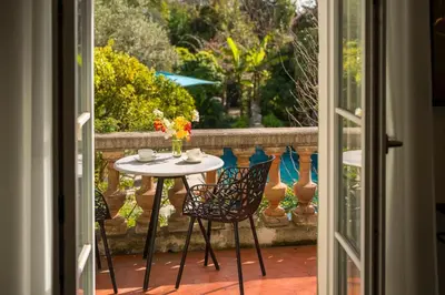 a table and chairs sitting on a patio with a window at Cannes centre maison bourgeoise in Cannes