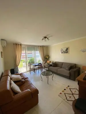 a living room with a couch and a table at 3 Pièces avec grande terrasse in Cannes