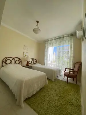 a bedroom with two beds and a chair and a window at 3 Pièces avec grande terrasse in Cannes