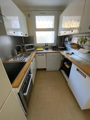 a kitchen with white cabinets and a white refrigerator at 3 Pièces avec grande terrasse in Cannes