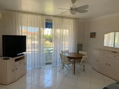 a living room with a dining room table and a television at T2 à proximité des plages in Cannes