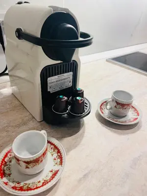 a coffee maker with two cups and saucers on a counter at APRT Cannes Beach Festival ARNESE in Cannes