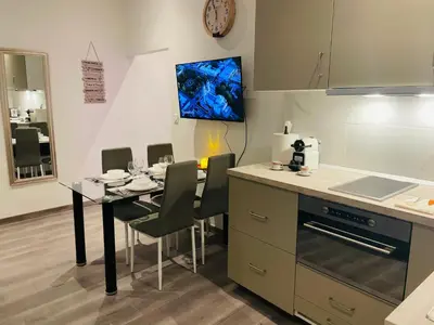 a kitchen with a table with chairs and a clock on the wall at APRT Cannes Beach Festival ARNESE in Cannes