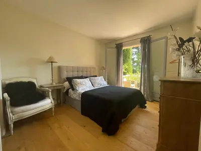 a bedroom with a bed and a chair and a window at Carolienne in Vallauris