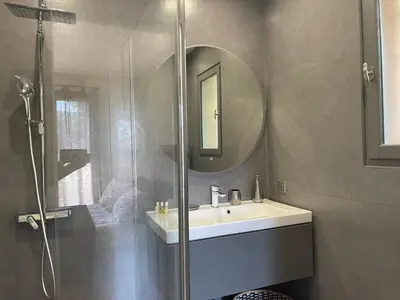 a bathroom with a shower and a sink and a mirror at Carolienne in Vallauris