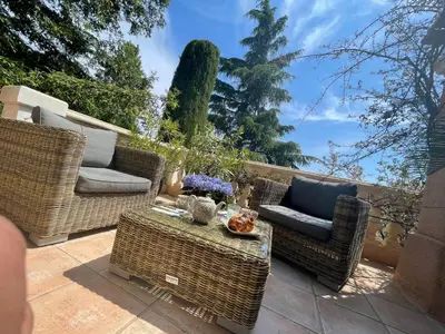 a patio with wicker chairs and a table at Carolienne in Vallauris