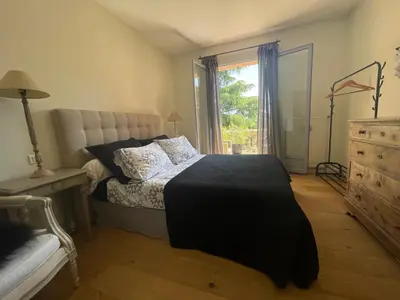 a bedroom with a bed and a dresser and a window at Carolienne in Vallauris