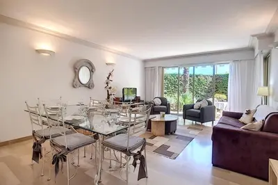 a living room with a glass table and chairs at 2 bdr apartment with garden next to the Croisette in Cannes