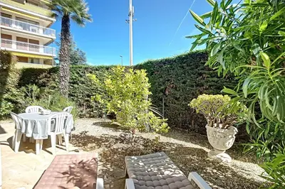 a patio with a table and chairs in a garden at 2 bdr apartment with garden next to the Croisette in Cannes