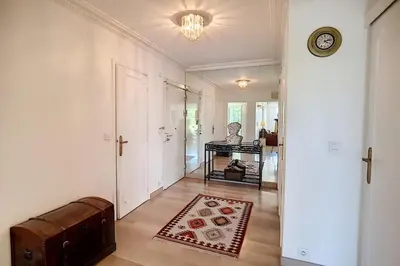 a hallway with a room with a clock on the wall at 2 bdr apartment with garden next to the Croisette in Cannes