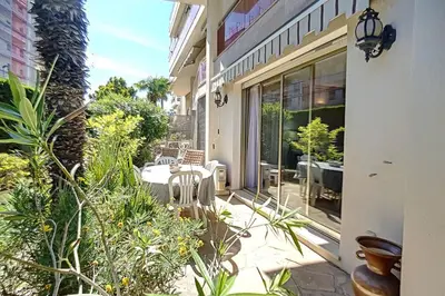 a balcony of a house with a table and chairs at 2 bdr apartment with garden next to the Croisette in Cannes