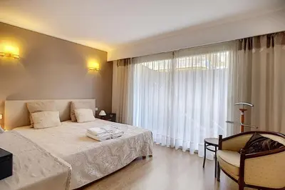 a bedroom with a bed and a large window at 2 bdr apartment with garden next to the Croisette in Cannes