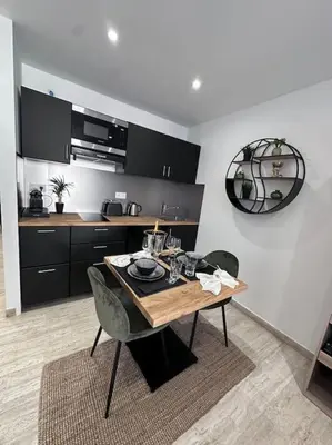 a dining room with a table and chairs in a kitchen at Superbe Studio avec balcon Rue d’Antibes in Cannes