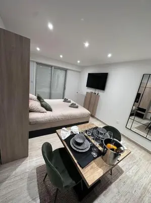 a living room with a bed and a table in a room at Superbe Studio avec balcon Rue d’Antibes in Cannes