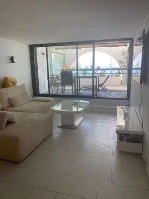 a living room with a couch and a table at Appartement Front de mer à Cannes -Vue Mer & Terrasse in Cannes