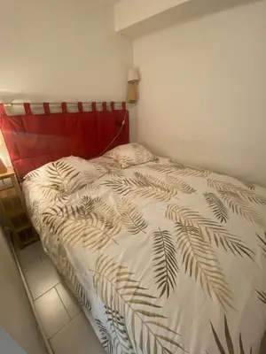 a bedroom with a bed with a red head board at Appartement Front de mer à Cannes -Vue Mer & Terrasse in Cannes
