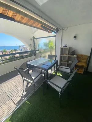 a dining table and chairs on a balcony with the beach at Appartement Front de mer à Cannes -Vue Mer & Terrasse in Cannes