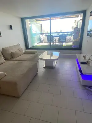 a living room with a couch and a table at Appartement Front de mer à Cannes -Vue Mer & Terrasse in Cannes