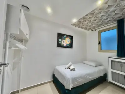 a white bedroom with a bed and a window at Colony 2 in Cannes