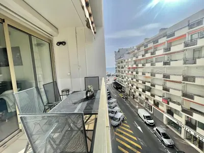 a balcony with a table and cars on a street at Colony 2 in Cannes