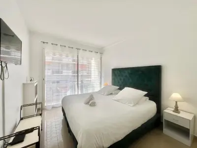 a bedroom with a large white bed with a window at Colony 2 in Cannes