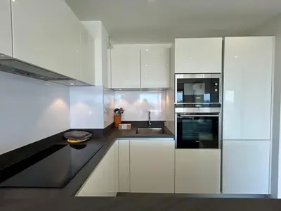 a kitchen with white cabinets and a sink at A013-Apt vue mer avec piscine et terrasse in Cannes