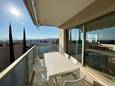 a balcony with a table and chairs and a view at A013-Apt vue mer avec piscine et terrasse in Cannes