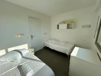a white room with two beds and a small room with two beds at A013-Apt vue mer avec piscine et terrasse in Cannes