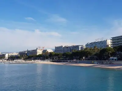 a view of a beach with buildings in the background at A069-Apt in residence with pool and sea view - Cannes in Cannes