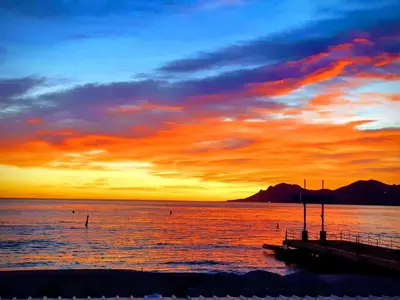 a sunset over a body of water with a pier at A069-Apt in residence with pool and sea view - Cannes in Cannes