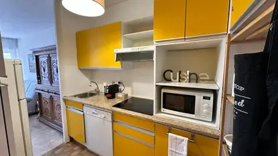 a kitchen with yellow cabinets and a microwave at A050-Studio avec jardin prive Cannes pres de la plage in Cannes
