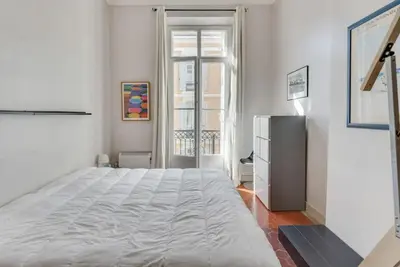 a white bedroom with a large bed and a window at A084-Welcoming apartment in Rue d'Antibes the heart of Cannes in Cannes