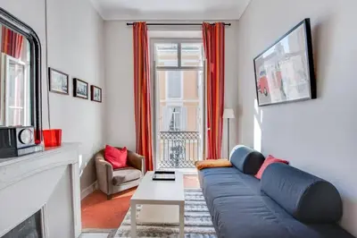 a living room with a blue couch and a fireplace at A084-Welcoming apartment in Rue d'Antibes the heart of Cannes in Cannes