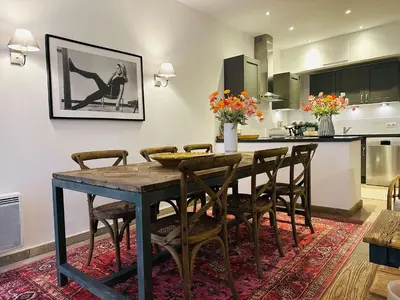 a kitchen and dining room with a wooden table and chairs at B005-Charmant appartement au coeur du Suquet in Cannes