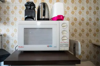 a white microwave sitting on top of a table at A081-Cannes Appartement avec terrasse au calme in Cannes