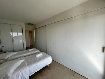 a bedroom with two beds and a large window at A018-Large studio with sea view swimming pool garage in Cannes