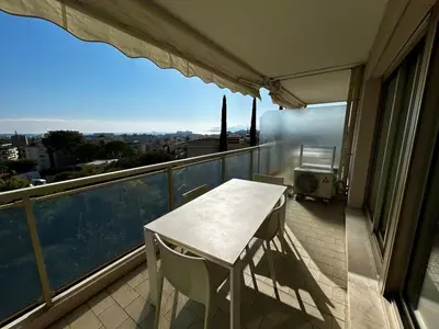 a table and chairs on a balcony with a view at A018-Large studio with sea view swimming pool garage in Cannes