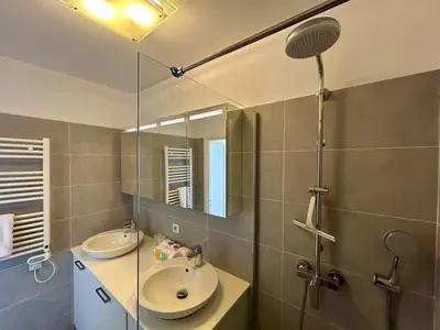 a bathroom with a sink and a shower with a mirror at A018-Large studio with sea view swimming pool garage in Cannes