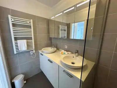 a bathroom with two sinks and a mirror at A018-Large studio with sea view swimming pool garage in Cannes
