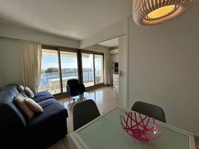 a living room with a couch and a glass table at A018-Large studio with sea view swimming pool garage in Cannes